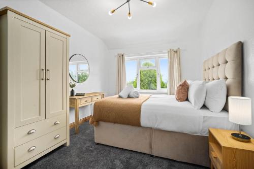 ein Schlafzimmer mit einem Bett, einer Kommode und einem Fenster in der Unterkunft Luxurious 3 Bedroom House with Parking 73B - Top Rated - Netflix - Wifi - Smart TV in Holly Lane