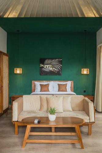 a living room with a couch and a green wall at Jetian villa in Nusa Lembongan