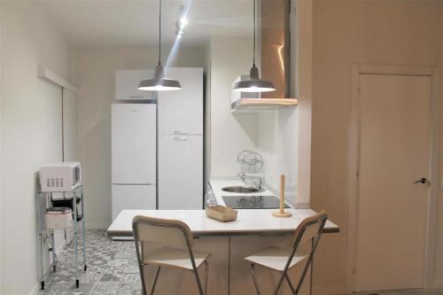 - une cuisine avec une table, des chaises et un évier dans l'établissement Apartamento Nuncio Viejo by Toledo AP, à Tolède