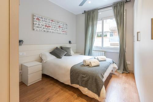 a bedroom with a white bed and a window at Apartamento Sarria-Sant Gervasi in Barcelona