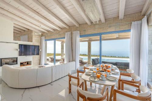 a living room with a table and chairs and a couch at My Kefalonia Villa in Minia