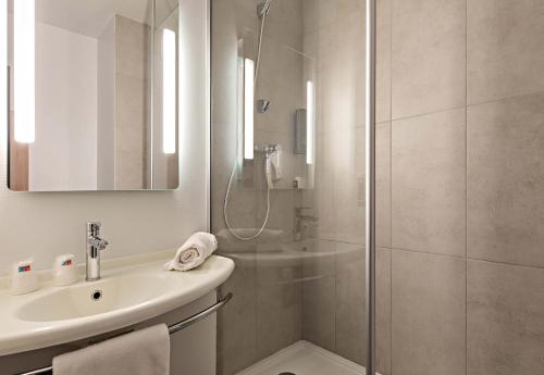 La salle de bains est pourvue d'une douche et d'un lavabo. dans l'établissement B&B HOTEL Rouen Centre Rive Gauche, à Rouen