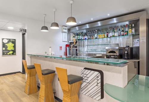a bar with chairs and a counter in a restaurant at B&B HOTEL Rouen Centre Rive Gauche in Rouen