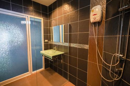 ein Bad mit einer Dusche, einem Waschbecken und einem Spiegel in der Unterkunft KARON STUDIO APARTMENT in Ka Rorn