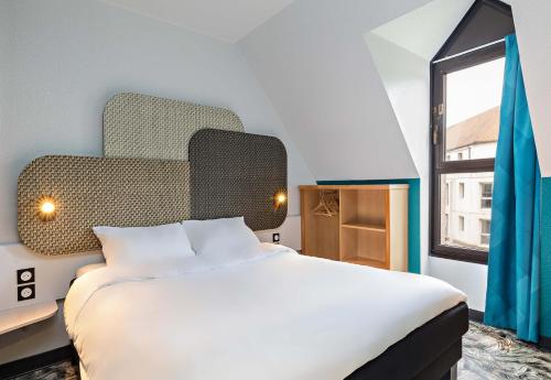 ein Schlafzimmer mit einem großen weißen Bett und einem Fenster in der Unterkunft B&B HOTEL Rouen Centre Rive Gauche in Rouen