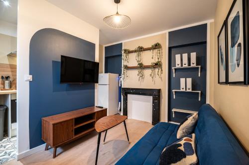 a living room with blue walls and a blue couch at Appartement Cosy Rouen in Rouen