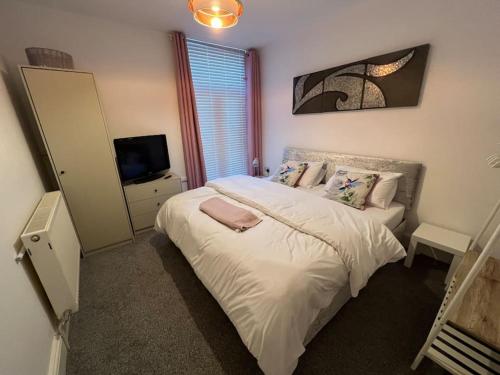 a bedroom with a large bed and a television at New Flat in Lytham St Annes - Sleeps 4 in Saint Annes on the Sea
