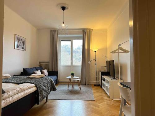 1 dormitorio con 1 cama y sala de estar con TV. en Stay Inn Apartment Sveavägen, en Estocolmo