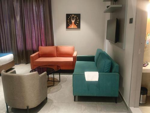 a living room with two chairs and a couch at Hotel Akruti, Nanded in Nānded