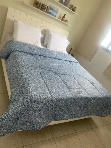 1 dormitorio con 1 cama con manta azul y almohadas en Apartamento vista Mar en Angra dos Reis