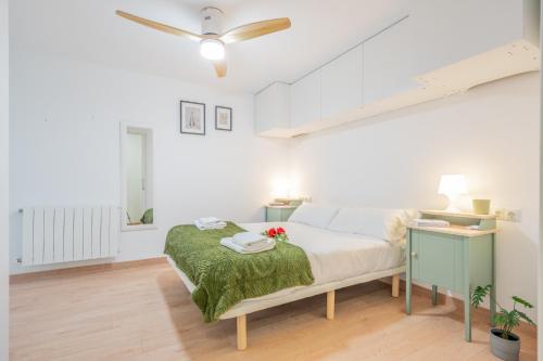 a white bedroom with a bed and a desk at Apartamento vive Patraix in Valencia