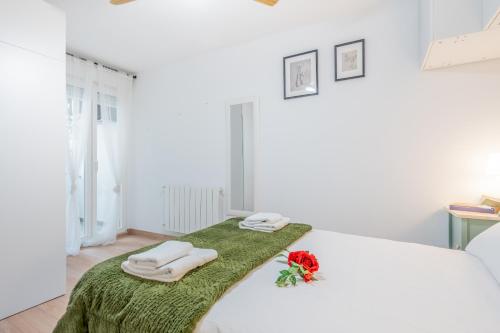 a bedroom with a white bed with towels on it at Apartamento vive Patraix in Valencia