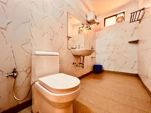 a bathroom with a toilet and a sink at Shivam Resort With Swimming Pool ,Managed By The Four Season - 1 km from Calangute Beach in Goa