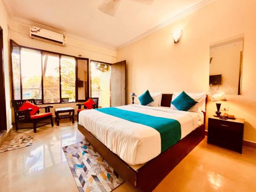 a bedroom with a large bed and a living room at Shivam Resort With Swimming Pool ,Managed By The Four Season - 1 km from Calangute Beach in Goa