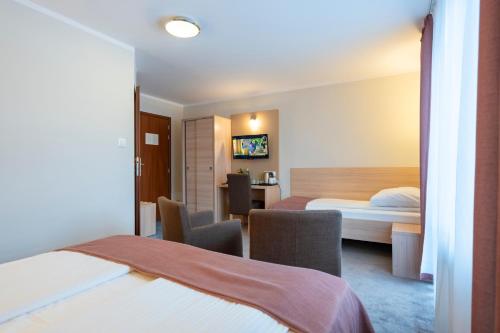 a hotel room with a bed and a desk at Pensjonat Carmen in Szklarska Poręba