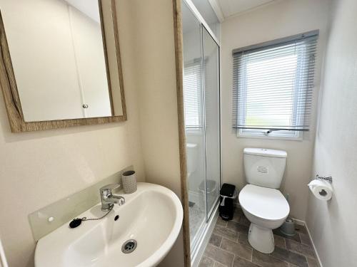 y baño con lavabo, aseo y espejo. en 70 Porth Valley Retreat, en Newquay Bay Resort