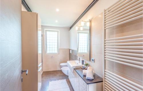 bagno con servizi igienici, lavandino e specchio di 3 Bedroom Nice Home In Lazise Vr a Lazise