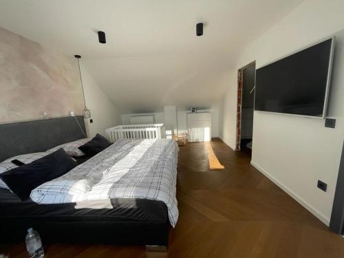 a bedroom with a large bed and a flat screen tv at Lot in Zagreb