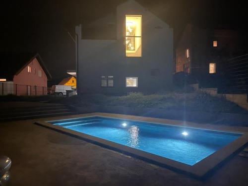 a swimming pool in front of a house at night at Lot in Zagreb