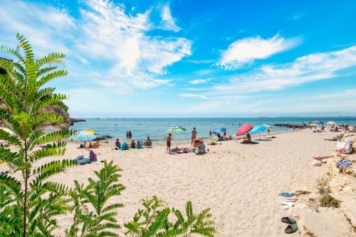 a group of people on a beach with umbrellas at Marina View Fort Beach in Sveti Vlas