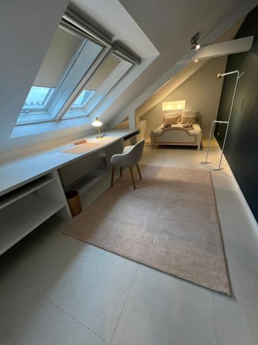 a attic room with a desk and a bed at Velo Villa in Achel