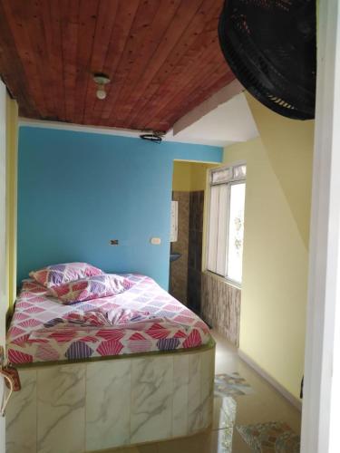 1 dormitorio con 1 cama con pared azul en Hotel y restaurante Don Hato, en Buenaventura