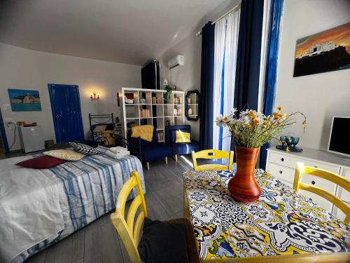 ein Schlafzimmer mit einem Bett und einem Tisch mit Blumen darauf in der Unterkunft Napoli Da Vivere Suites Giudecca in Neapel