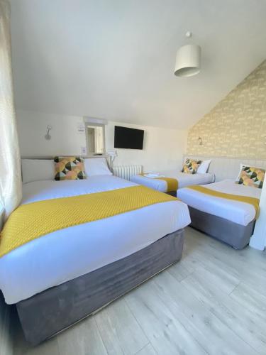 a bedroom with two beds and a flat screen tv at The Town House Hotel in Naas