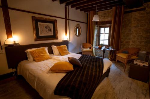 a bedroom with a large bed with yellow pillows at Domaine de la Pommeraye & Spa in La Pommeraye
