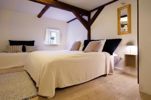 a bedroom with a bed with a white comforter at Købmandsgaarden Kerteminde in Kerteminde