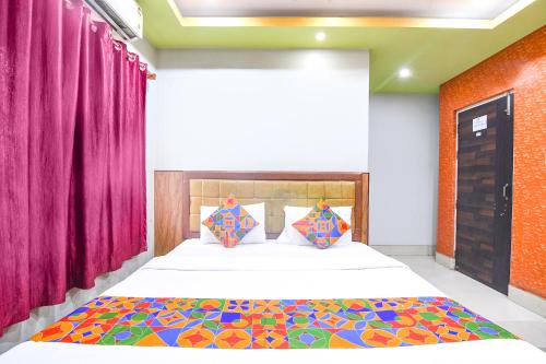 a bedroom with a large bed with purple curtains at FabHotel Stay Inn II in kolkata