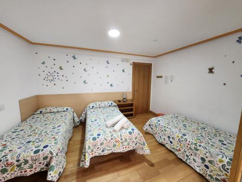 a bedroom with two beds and butterflies on the wall at Caminante in Belorado