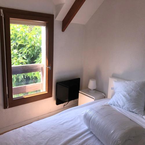 une chambre avec un lit et une fenêtre dans l'établissement Maison vacances jardin mer proche, à Guérande