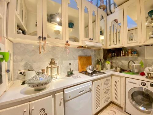 Douar el Hafey的住宿－Dar Zahra - Sidi Bou Said，厨房配有白色橱柜、水槽和洗碗机。