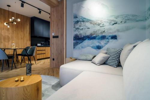 a living room with a white couch and a table at Podhalańskie Marzenie by Apart Concept Podhale in Kościelisko