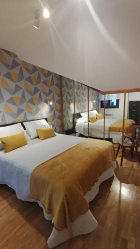 a bedroom with a large bed with yellow pillows at REY AURELIO 2 in Cangas de Onís