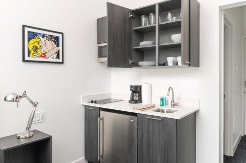 a kitchen with black cabinets and a white counter top at Stylish Studio in Historic Boston #208 in Boston