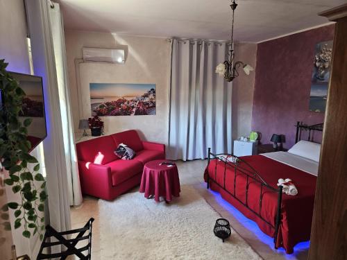 a bedroom with a red bed and a red couch at B&B Villa Maracujà in Ionadi