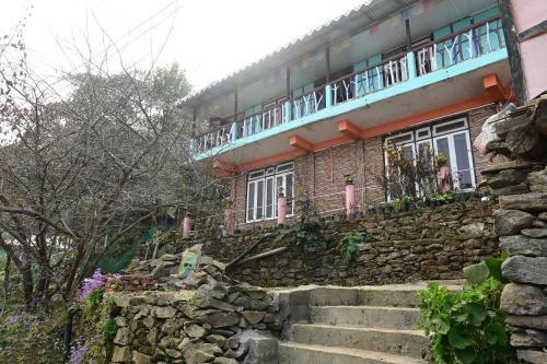 Pedong的住宿－Blue Pancy Homestay，前方有石墙和楼梯的建筑