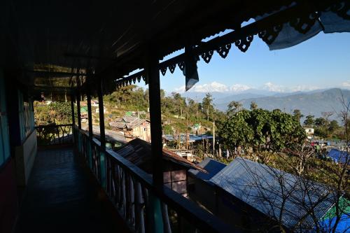 un balcón de una casa con vistas a las montañas en Blue Pancy Homestay, en Pedong