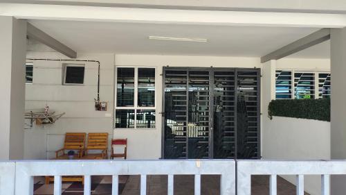 ein Haus mit schwarzen Türen und einem Balkon in der Unterkunft Homestay Ar-Rayyan Pokok Sena in Kampong Joo