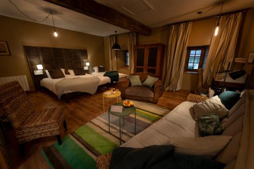 a living room with two beds and a couch at Domaine de la Pommeraye & Spa in La Pommeraye