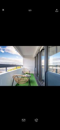 - un balcon avec deux chaises et une table dans l'établissement Superbe appartement Paris Sud: terrasse,parking, à Évry-les-Châteaux