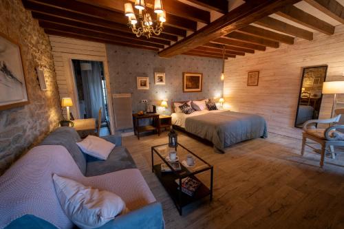 a bedroom with a bed and a couch in a room at Domaine de la Pommeraye & Spa in La Pommeraye