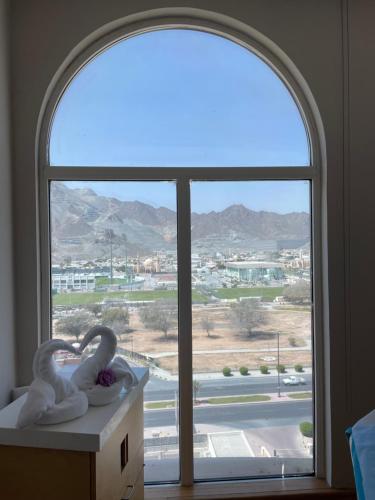 an arched window with two swan statues in front of it at Oceanic Khorfakkan Resort & Spa in Khor Fakkan