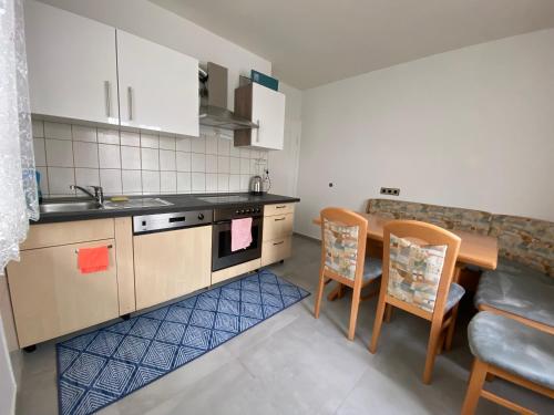 eine Küche mit einer Spüle sowie einem Tisch und Stühlen in der Unterkunft Comfort Apartment Heilbronn in Heilbronn