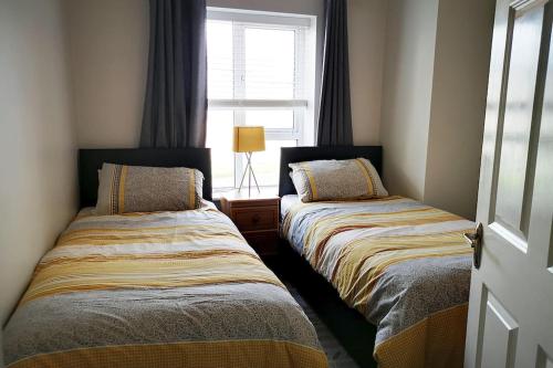 A bed or beds in a room at The Sandhills, Tramore Beach