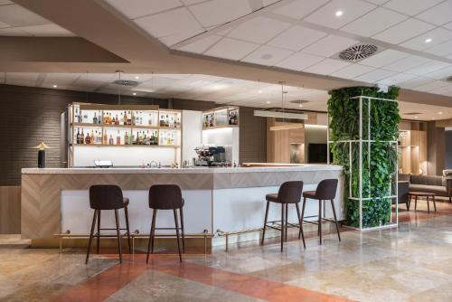 a bar in a hotel lobby with stools at Hilton Garden Inn Bologna North in Bologna