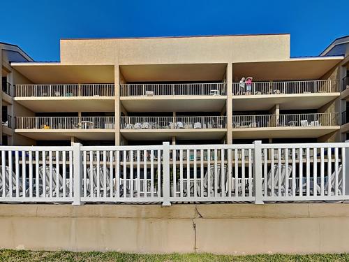 an apartment building with white tables and chairs at Laguna Reef #205 - La Las in Rockport