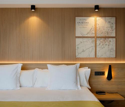 a bedroom with a bed with white pillows and a map at Nuvō Hotel Boutique in Oviedo